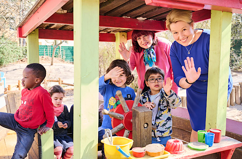 Bildungssenatorin Astrid-Sabine Busse und Bürgermeisterin Franziska Giffey (r.) auf dem Außengelände der INA-Kindertagesstätte in Berlin-Schöneberg. Die Kinder (von links nach rechts) heißen Triomph, Leopoldine, Jona und Robin.