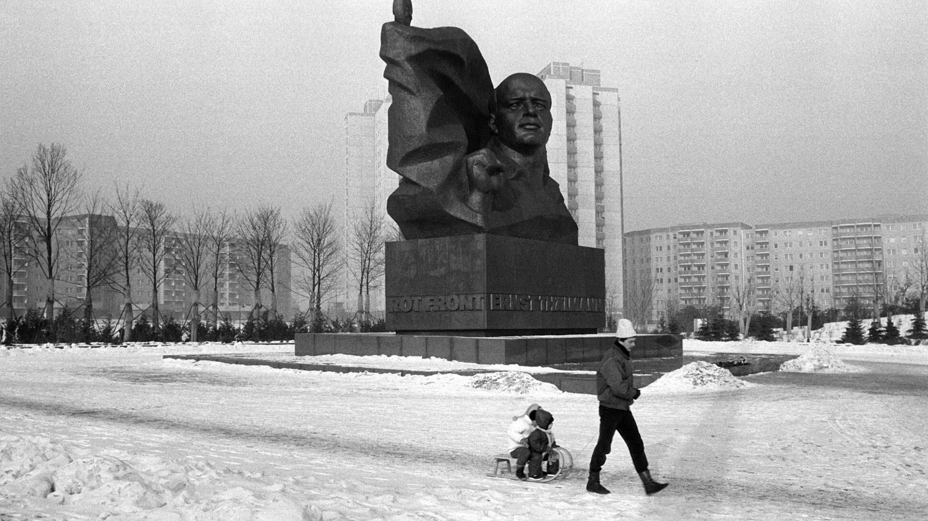 Ein Jahr nach seiner Aufstellung: Ein Vater zieht im Winter 1987 seine Kinder auf einem Schlitten, vorbei am Thälmann Denkmal.