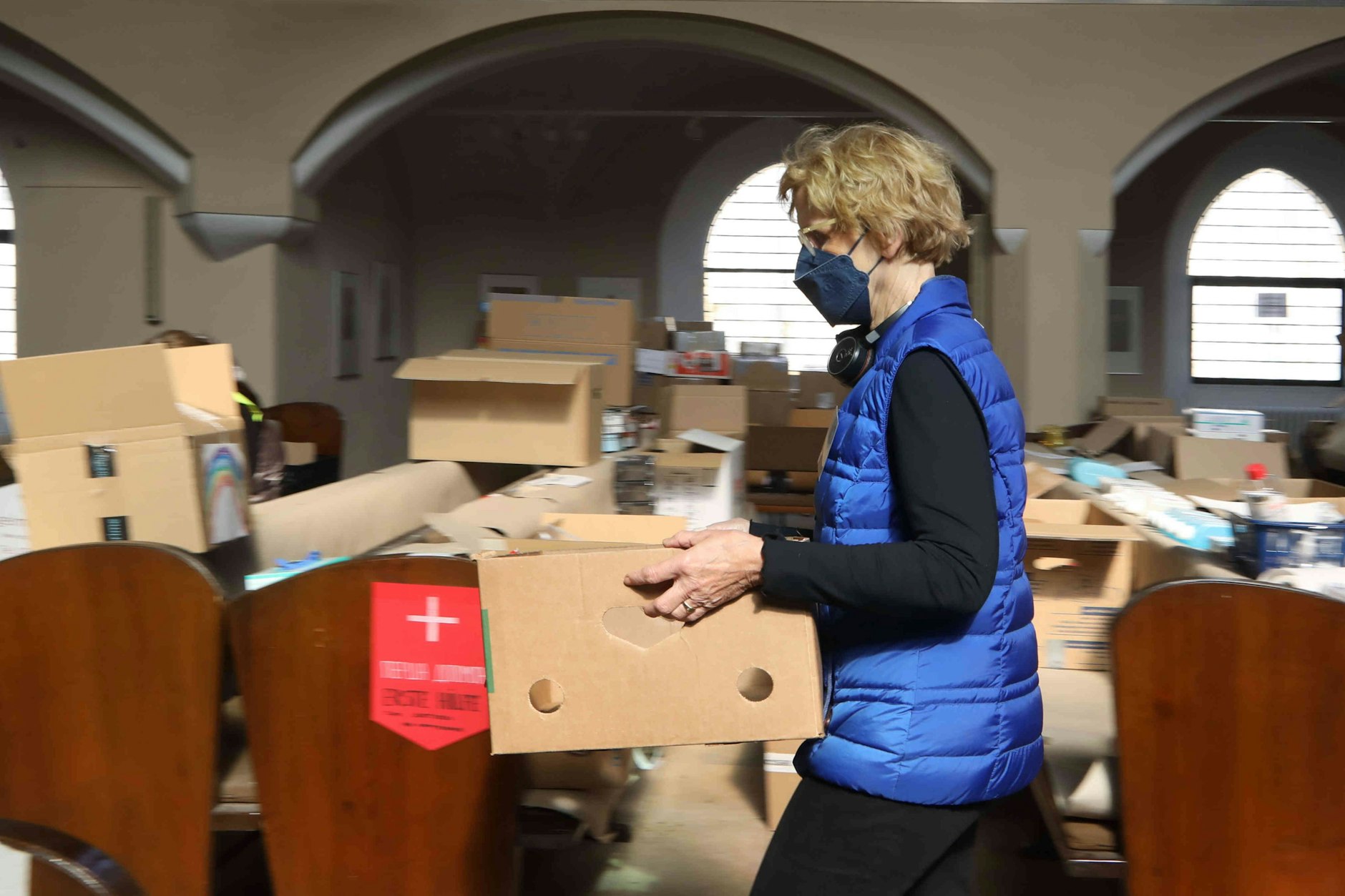 Eine Helferin packt in der Friedenauer Nathanael-Kirche Spenden für die Ukraine.