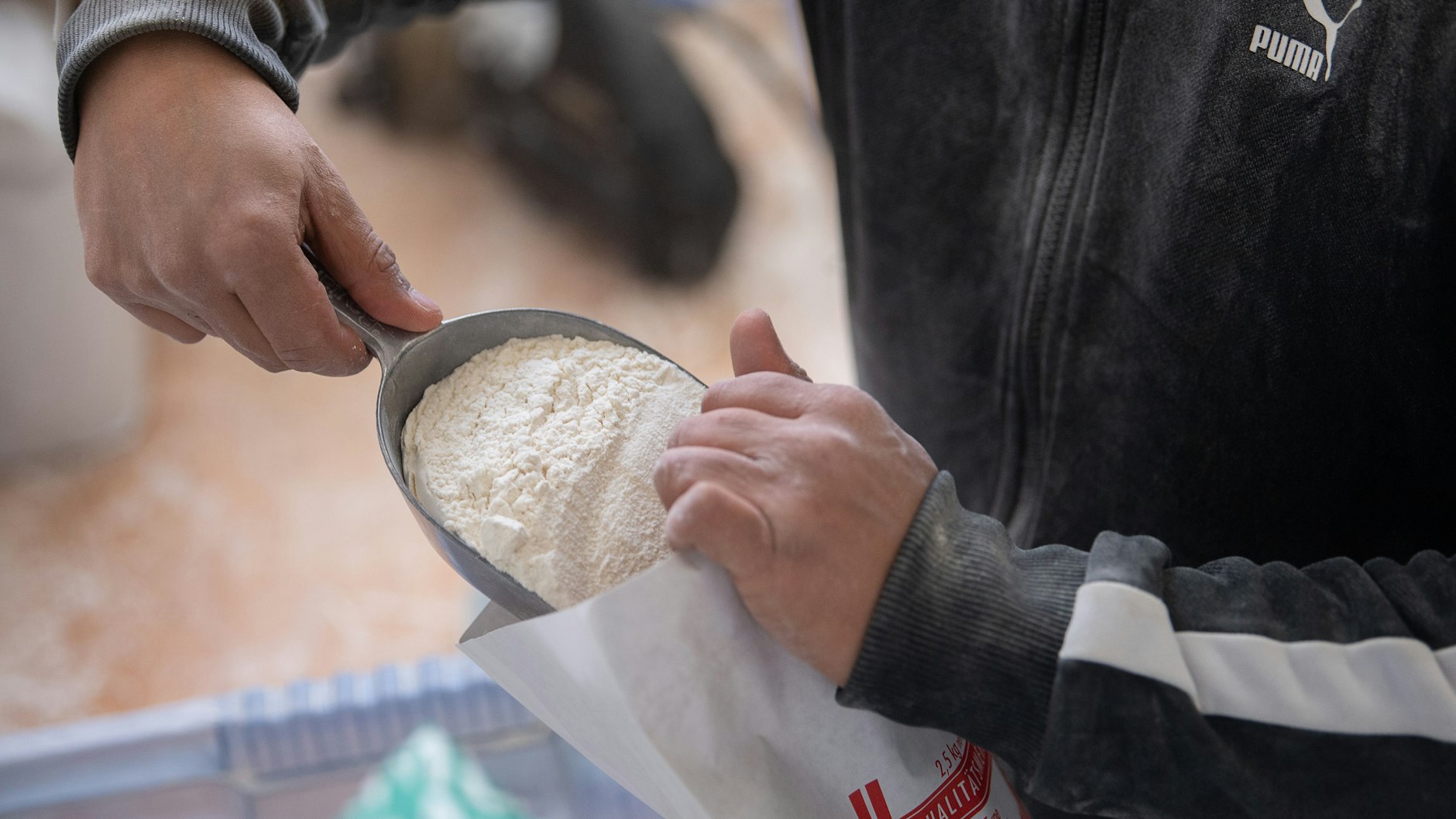 Ein Mitarbeiter füllt in der Philippi Mühle in Hessen&nbsp; 405er Mehl in einen 5-KG-Sack.