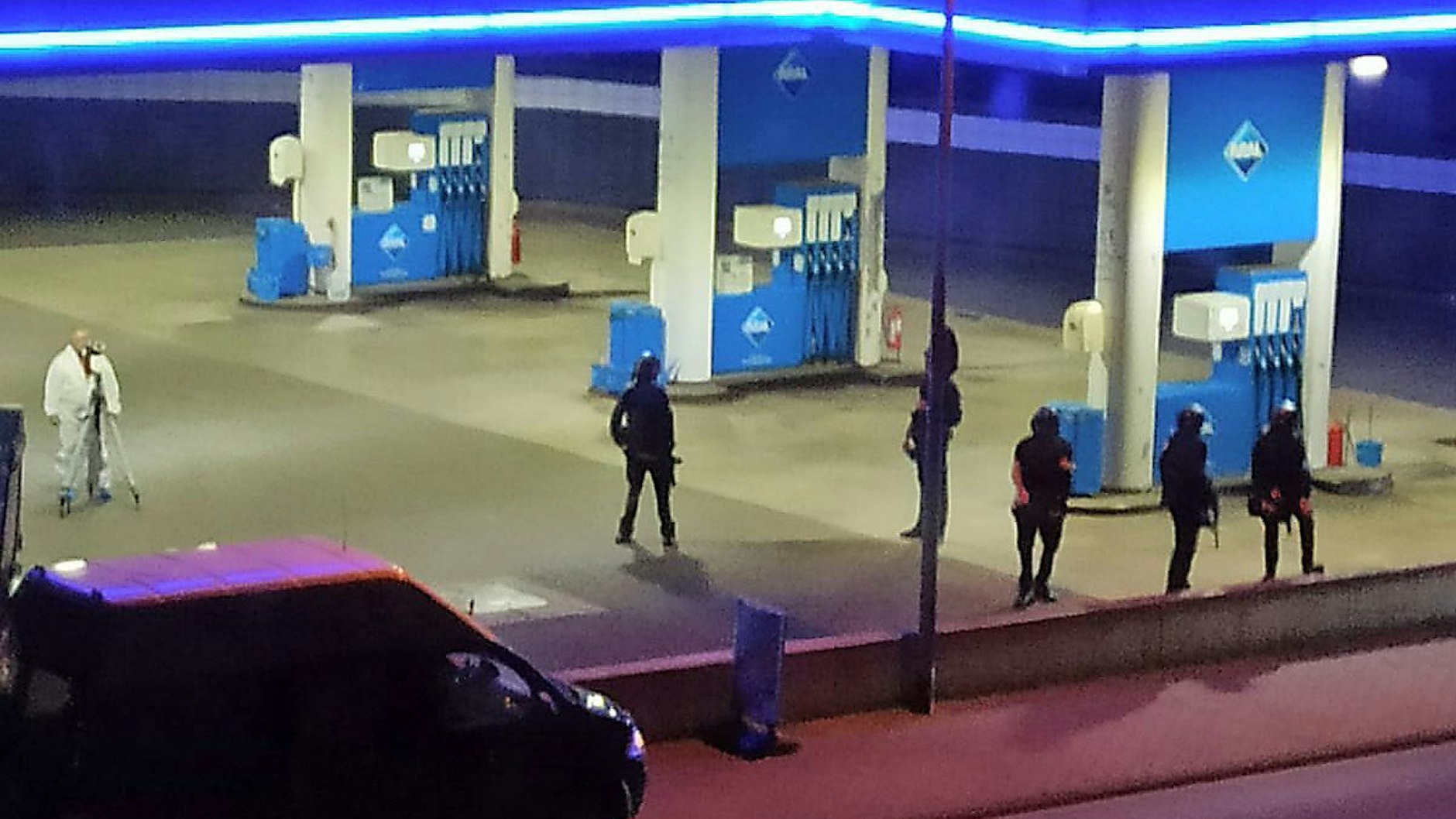 Polizisten sichern eine Tankstelle nach der Bluttat.