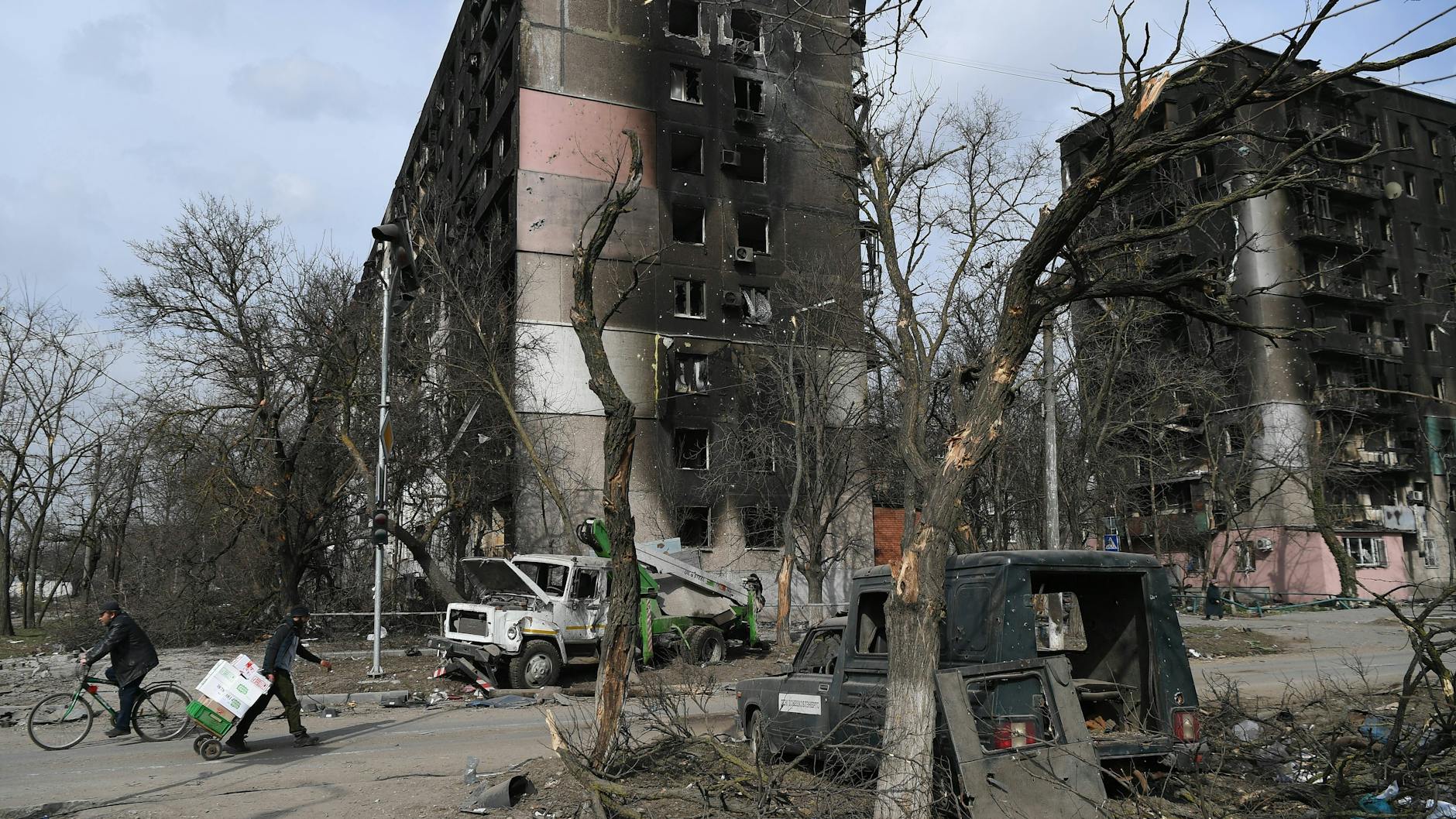Ausgebrannte Wohnhäuser und demolierte Autos in der von russischen Truppen belagerten ukrainischen Stadt Mariupol.