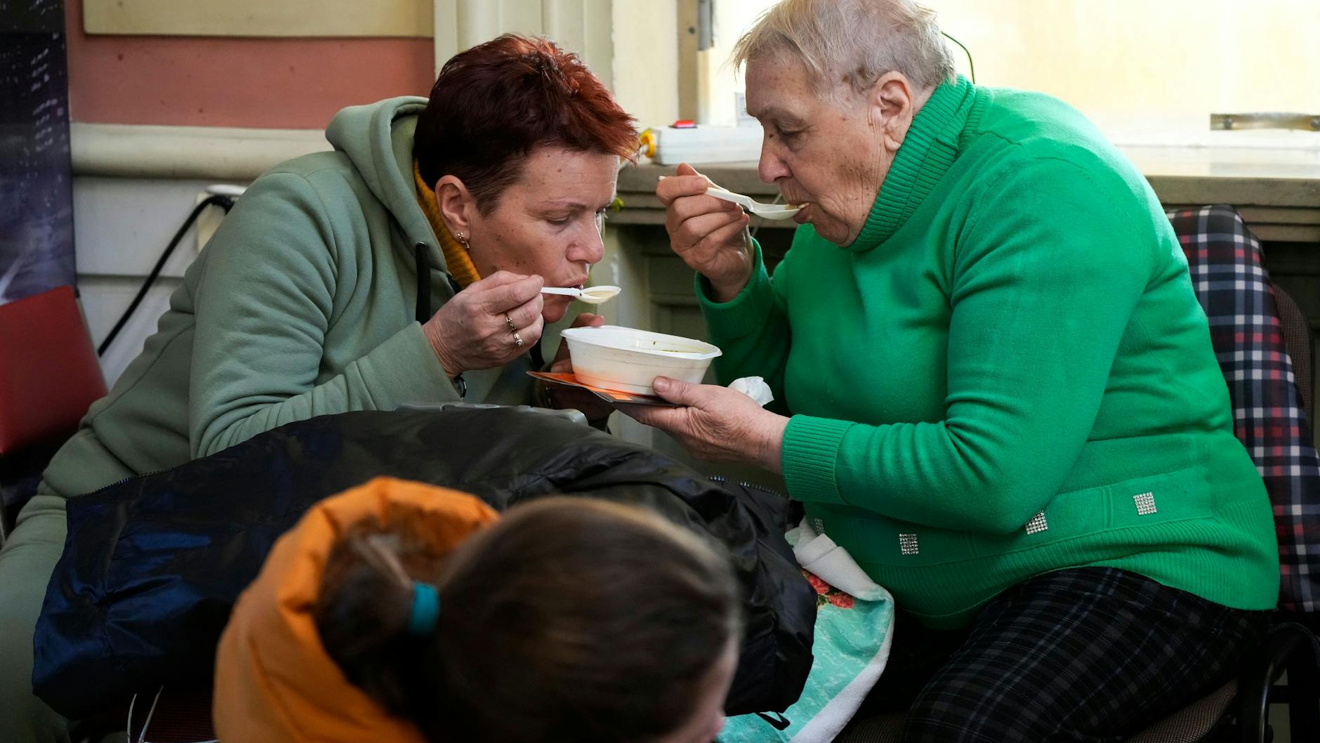 Ukrainische Geflüchtete essen eine warme Suppe am Bahnhof von Przemysl.