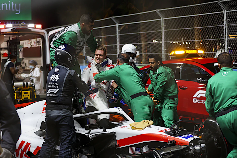 Mick Schumacher steigt nach dem Unfall mit Hilfe von Streckenposten aus dem Wrack.