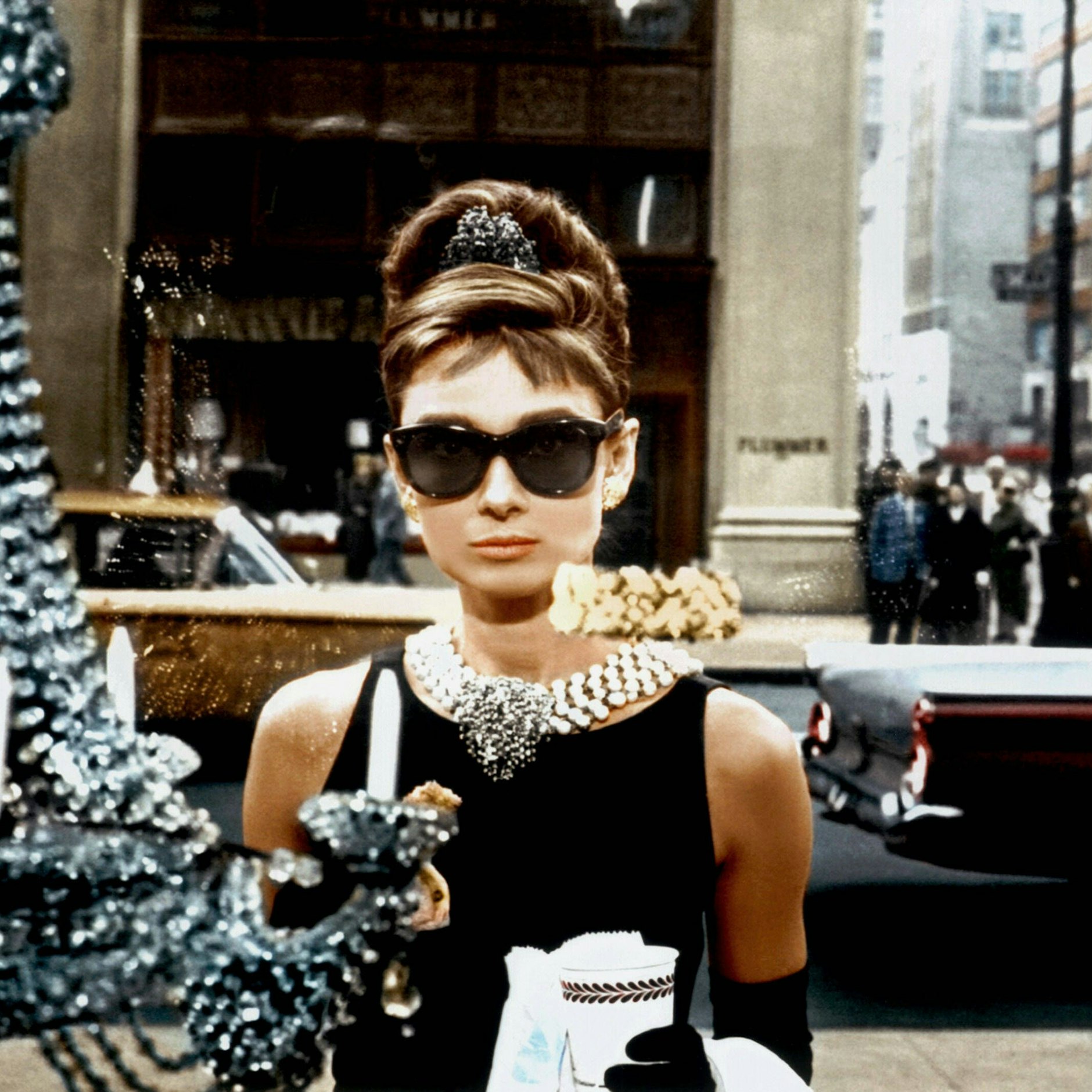 Audrey Hepburn als Holly Golightly mit einer Sonnenbrille von Oliver Goldsmith in „Breakfast At Tiffany's“ (1961). Das Originalmodell von Oliver Goldsmith&nbsp;heißt „Manhattan“ und kostet 360 Euro. Für 85 Euro extra kann man Initialen in den Bügel gravieren lassen.