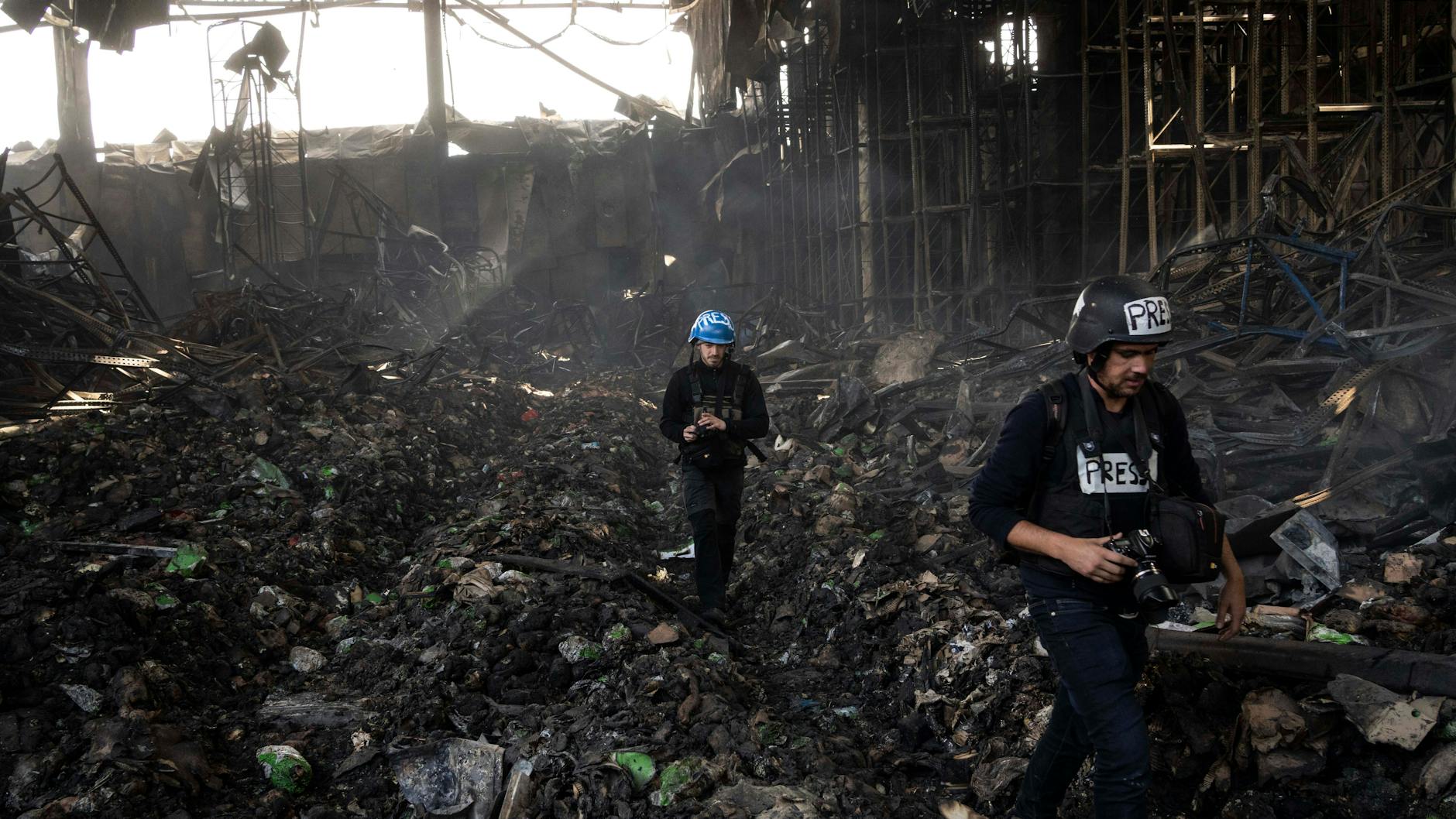 Journalisten gehen in ein zerstörtes Lagerhaus nach einem Angriff aus Russland vor zwölf Tagen.