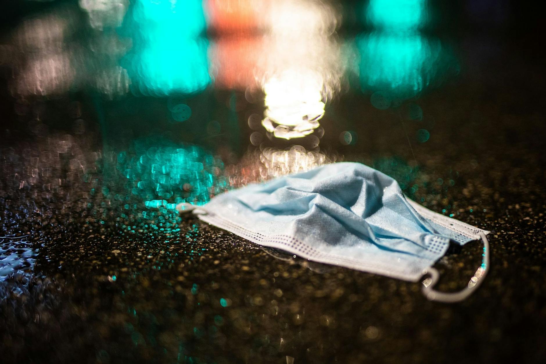 Ein Mund-Nasenschutz liegt im Regen auf der Straße. Einkaufen soll künftig auch ohne Maske gehen. Aber: muss man sich darauf wirklich einlassen?