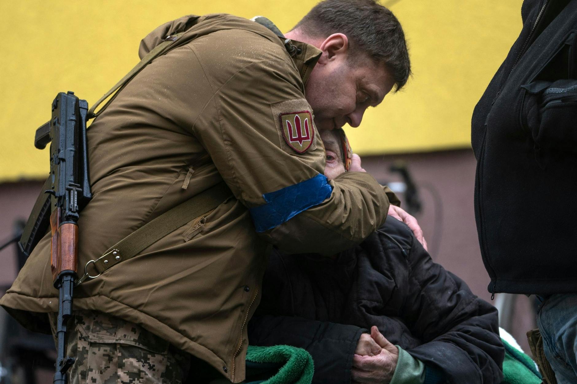 Ein ukrainischer Soldat tröstet eine ältere Frau, nachdem diese ihren Heimatort verlassen musste.