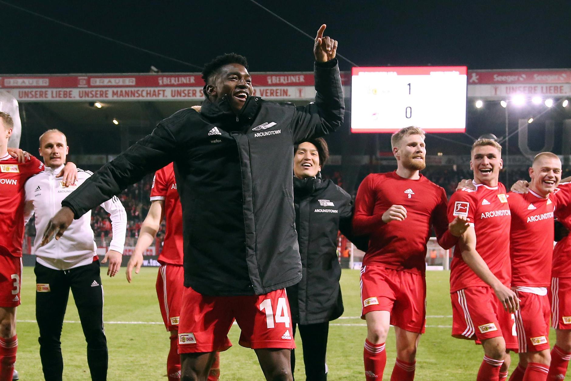 Unions Mannschaft feiert vor der voll besetzten Waldseite, Siegtorschütze Taiwo Awoniyi tanzt ausgelassen vor den Kollegen.