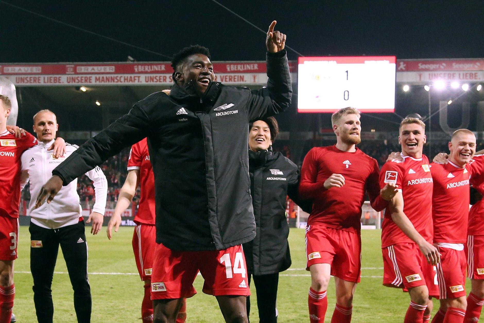 Unions Mannschaft feiert vor der voll besetzten Waldseite, Siegtorschütze Taiwo Awoniyi tanzt ausgelassen vor den Kollegen.