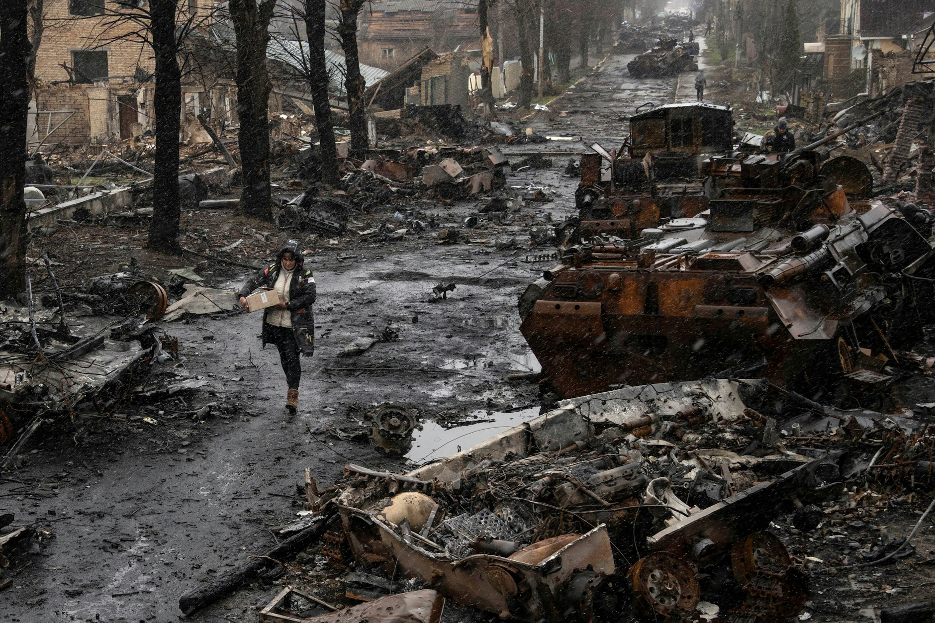 Eine Frau geht auf einer Straße in der ukrainischen Stadt Butscha.