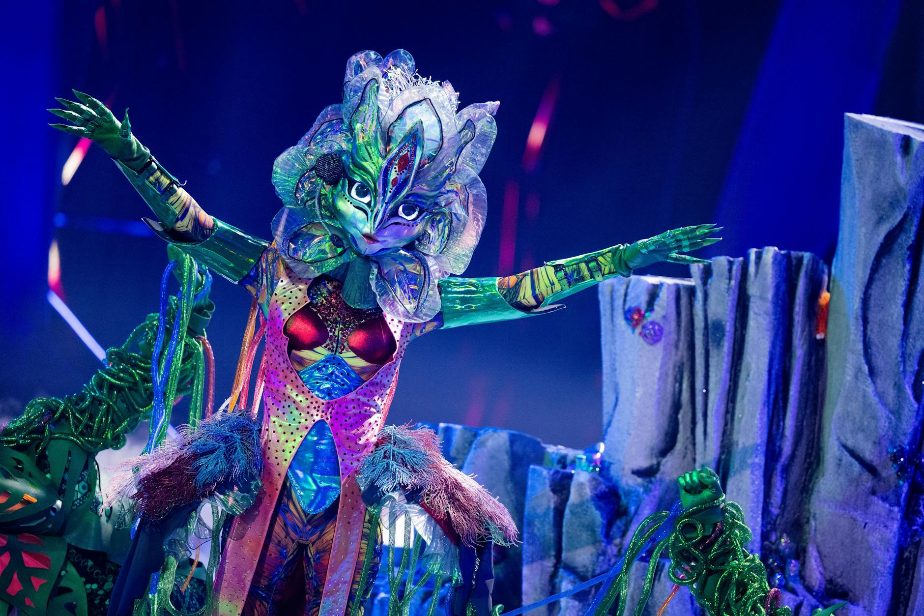Galax'sis auf der Bühne von The Masked Singer. Ihre Tänzer führen sie an den grünen Ranken über die Bühne.