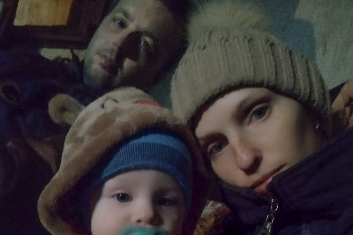Ruslan Bondarenko (hinten) mit seiner Frau Maria und ihrem Sohn Bohdan im Keller ihres Hauses in Butscha, Ukraine. Die Familie ist aus der Stadt wenige Tage vor ihrer russischen Einnahme geflüchtet.