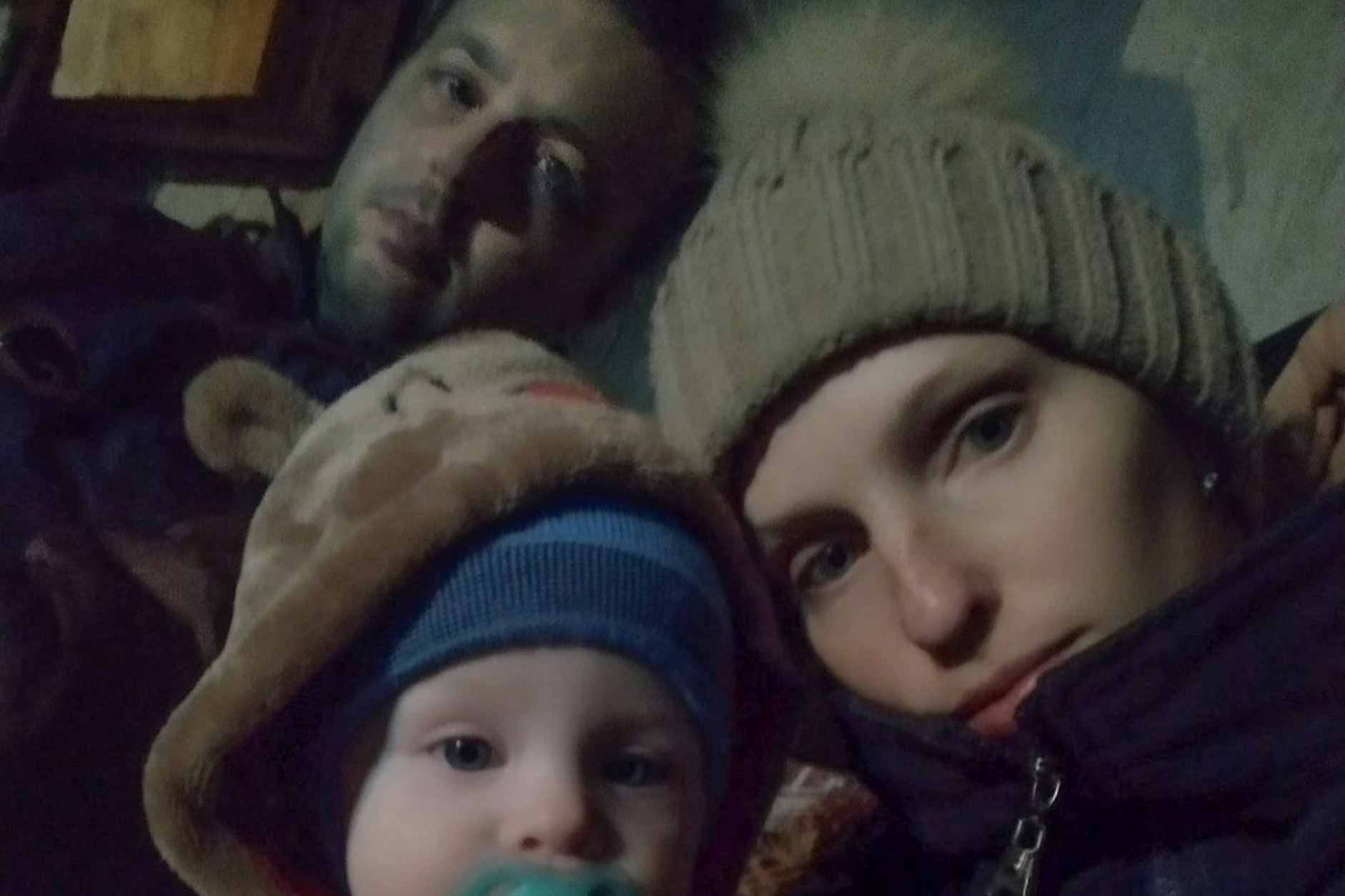 Ruslan Bondarenko (hinten) mit seiner Frau Maria und ihrem Sohn Bohdan im Keller ihres Hauses in Butscha, Ukraine. Die Familie ist aus der Stadt wenige Tage vor ihrer russischen Einnahme geflüchtet.