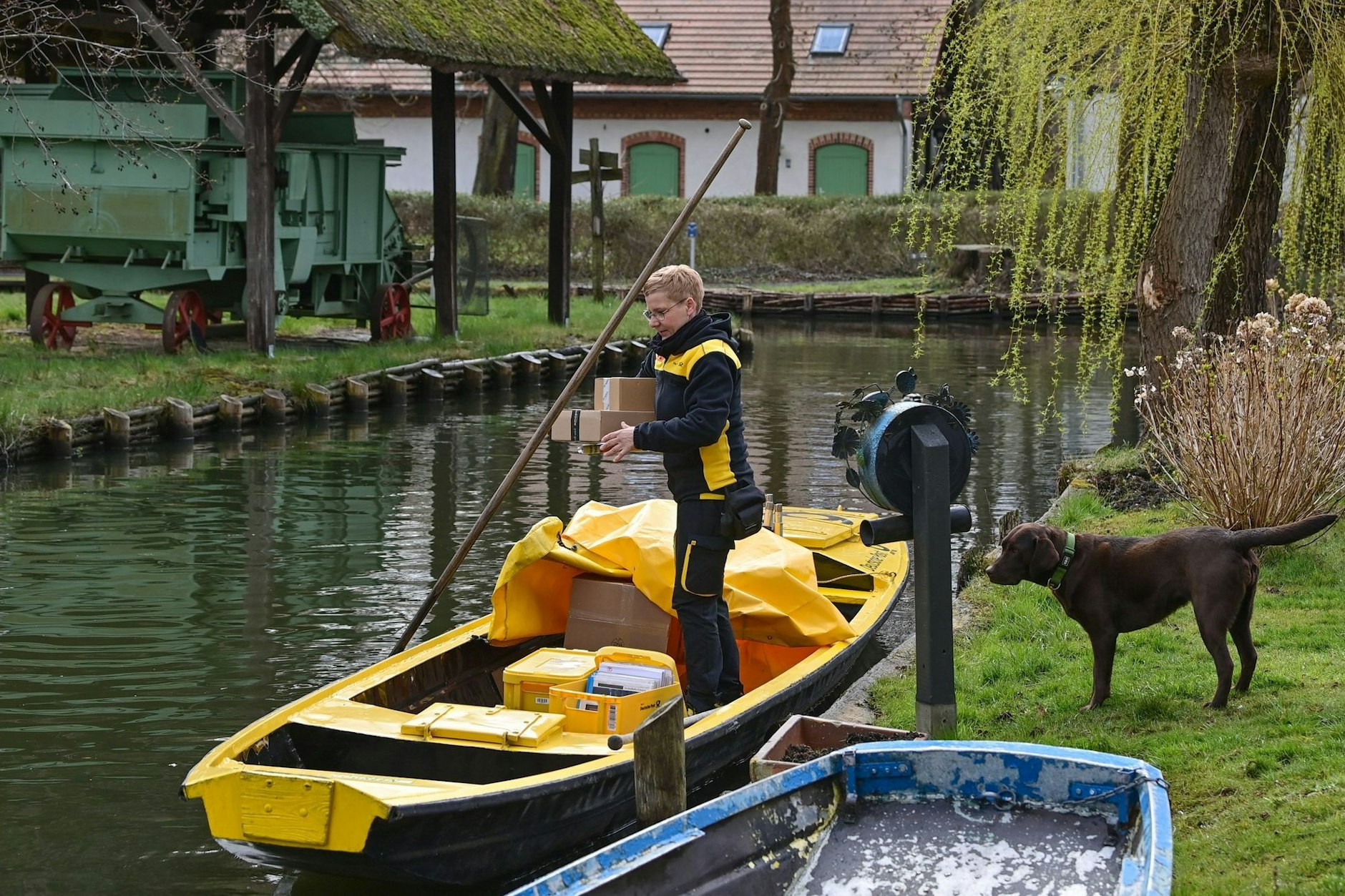 Postzustellerin Andrea Bunar ist zum Saisonbeginn mit ihrem gelben Postkahn auf einem Fließ unterwegs