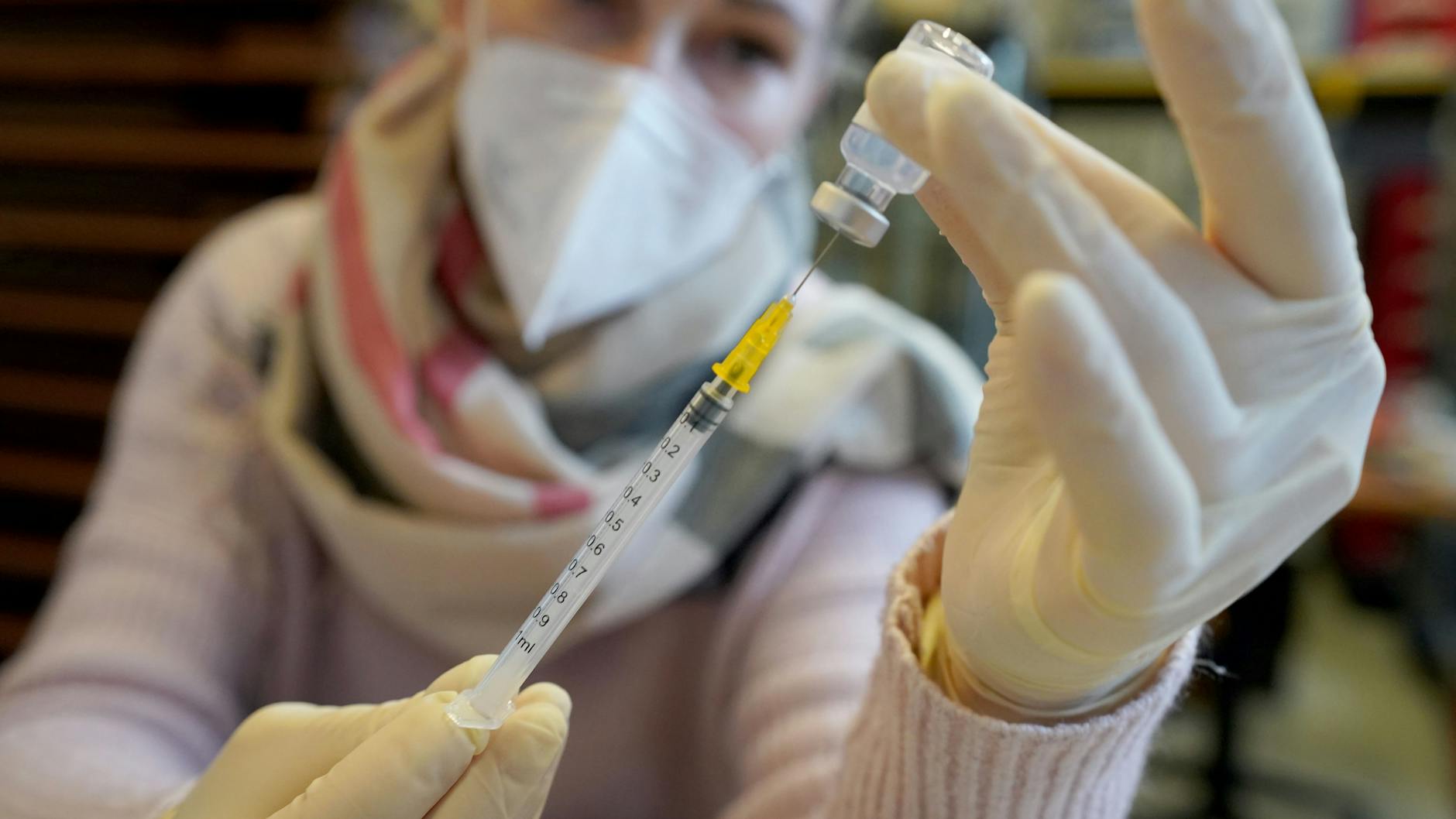 Eine Mitarbeiterin eines mobilen Impfteams bereitet Spritzen mit Impfstoff vor.