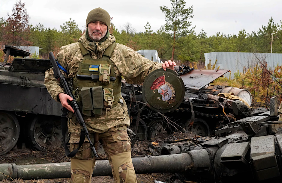 Ein ukrainischer Soldat vor einem zerstörten russischen Panzer in dem Ort Dmytrivka bei Kiew.