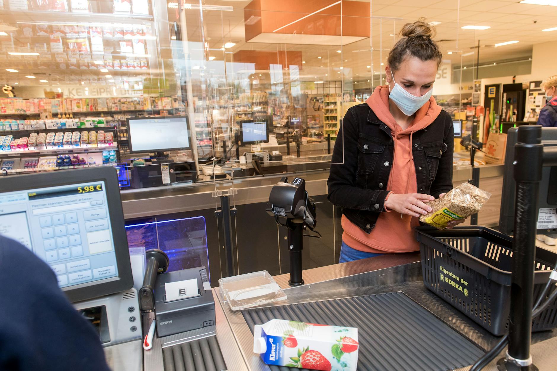 Eine Frau mit Mundschutz kauft in einem Supermarkt ein.