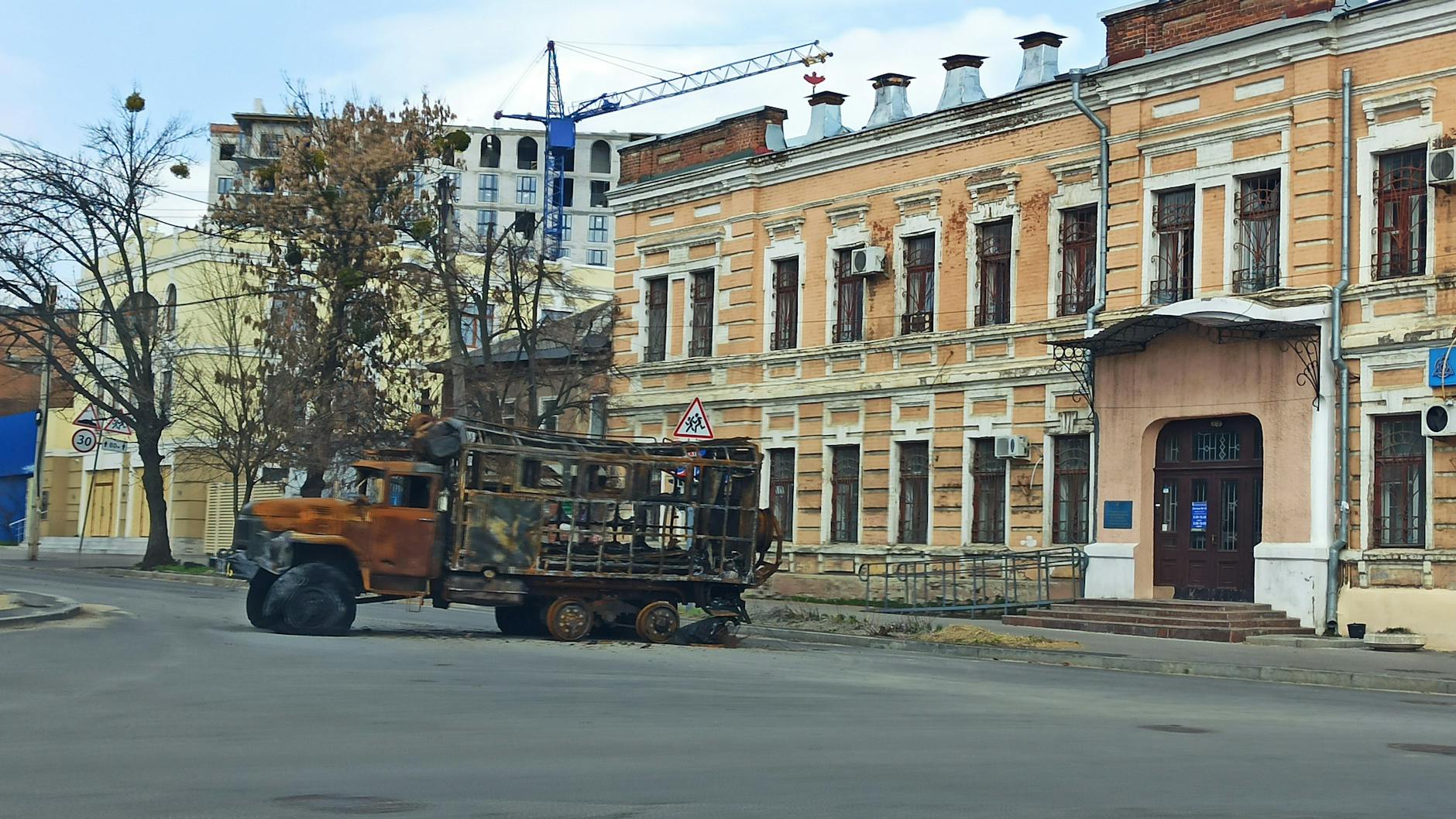 In den Straßen der Stadt stehen überall ausgebrannte Fahrzeugwracks.