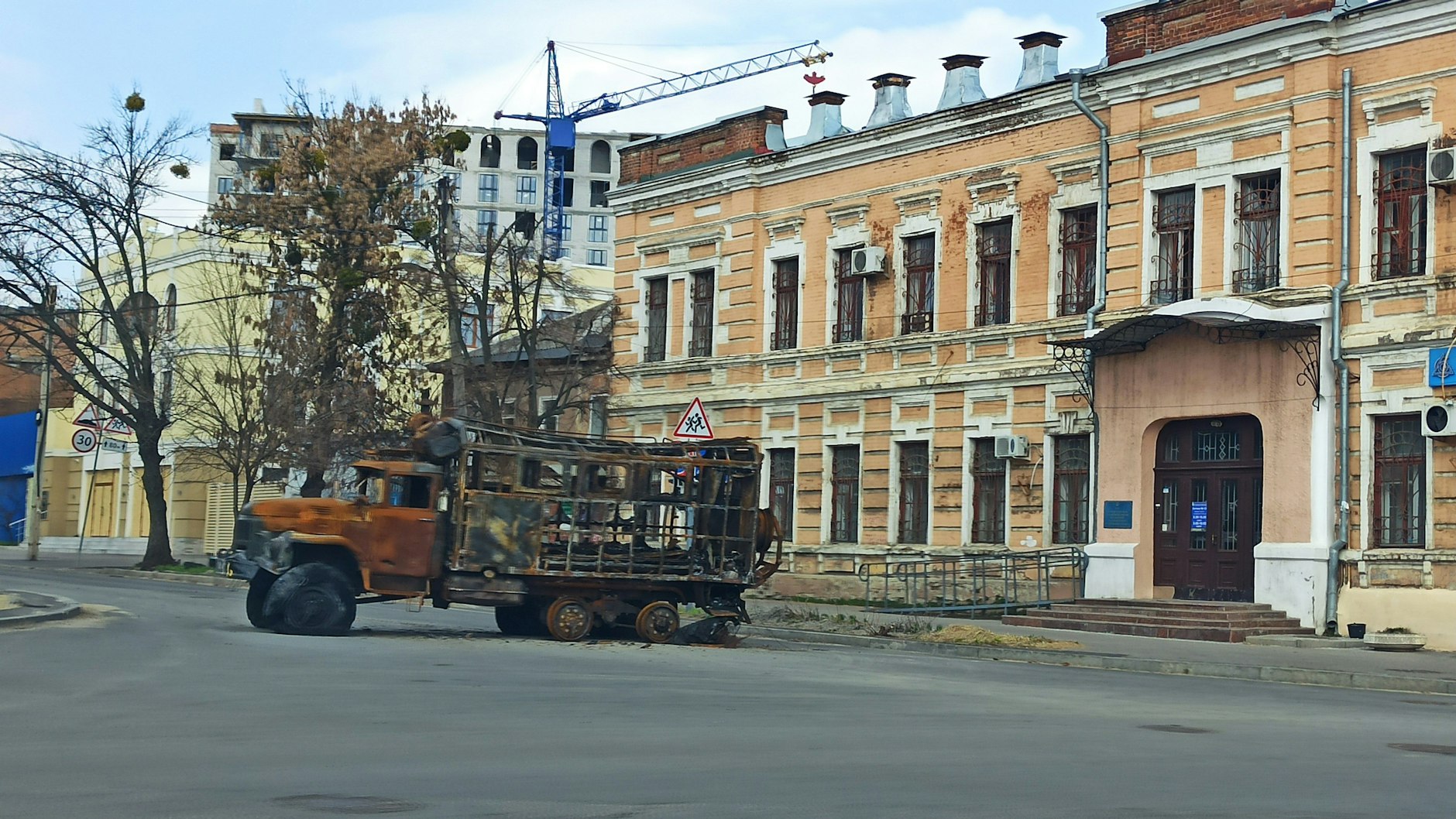 In den Straßen der Stadt stehen überall ausgebrannte Fahrzeugwracks.