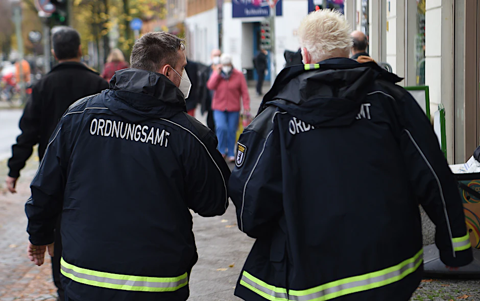 Mitarbeiter und Mitarbeiterinnen vom Ordnungsamt kontrollieren eine Straße in Berlin.