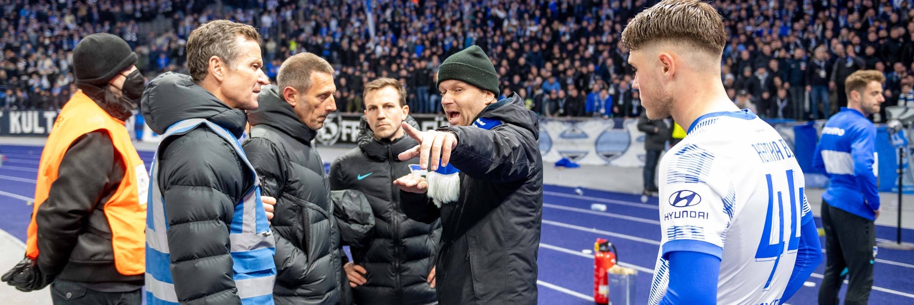 Thomas Herrich (2.v.l.), Mitglied der Geschäftsleitung, und Hertha-Pressesprecher Max Jung (3.v.l.) diskutierten nach dem Derby mit einem Ultra auf der Tartanbahn.
