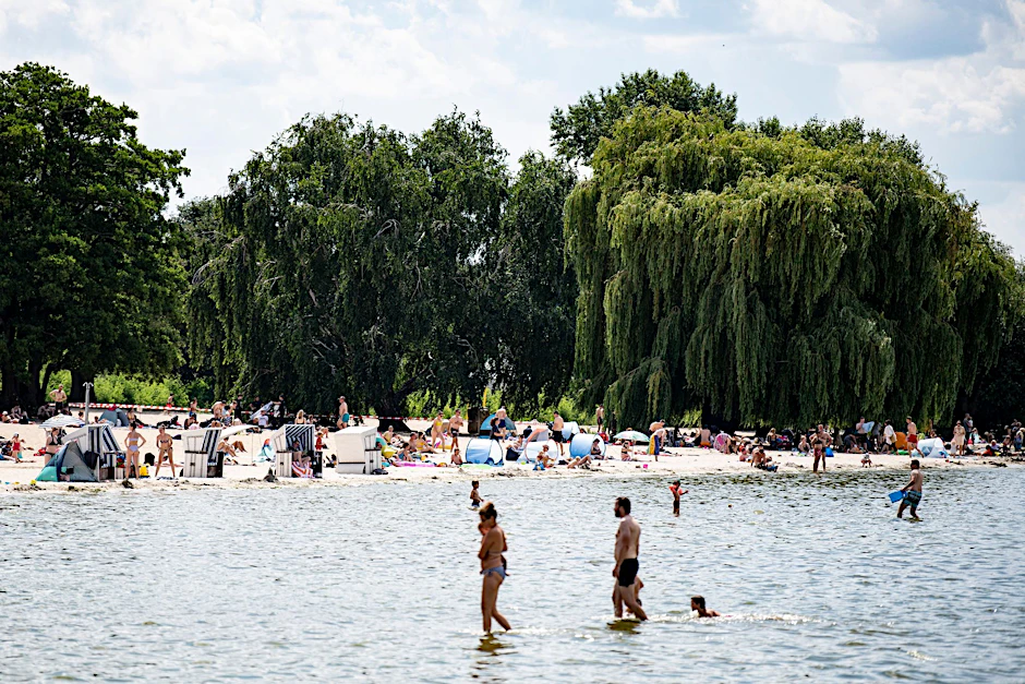 Besucher des Strandbades am Wannsee genießen das sonnige Wetter am Wasser.