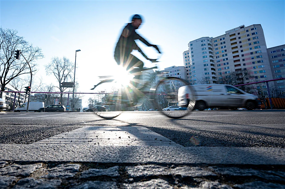 Ein Morgenpendler fährt mit dem Fahrrad über eine Kreuzung in Berlin-Schöneberg.