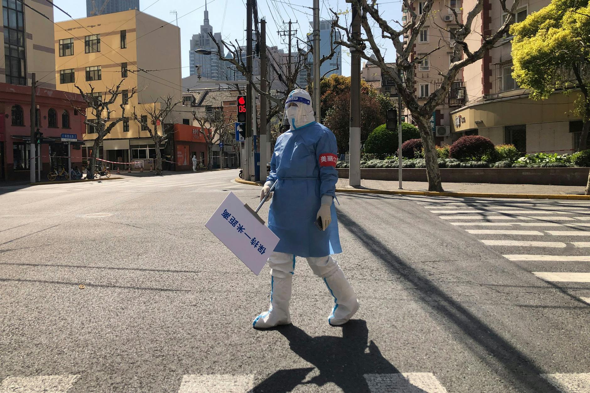 Eine Stadt hielt den Atem an: In menschenleerem Schanghai hält ein Gesundheitsmitarbeiter ein Schild, das zum Einhalten der 1-Meter-Abstandsregel erinnert.