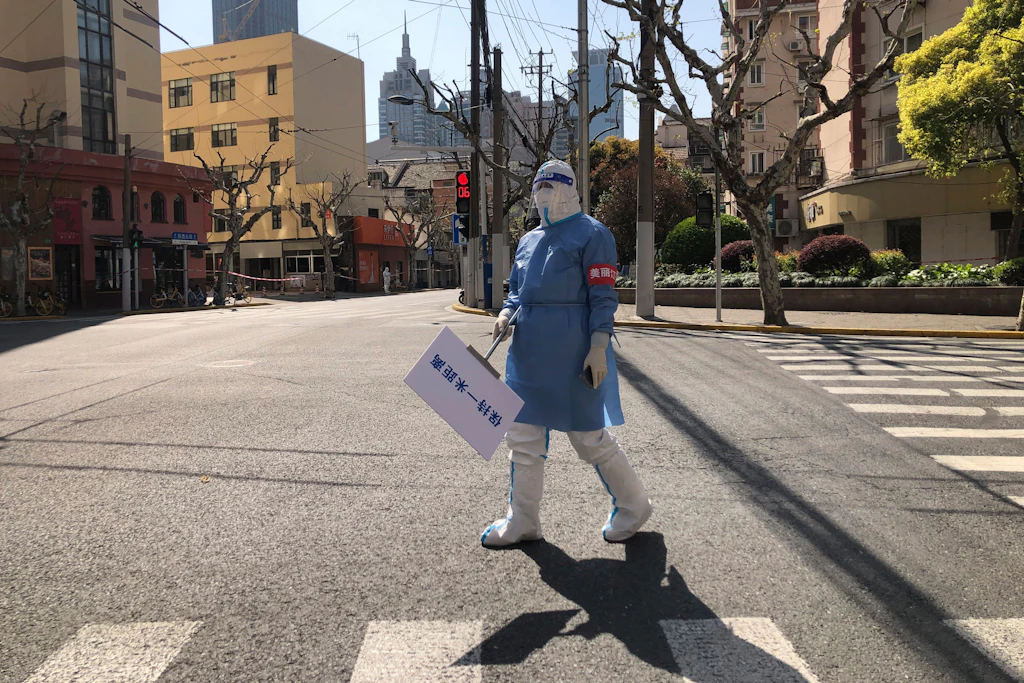 Eine Stadt hielt den Atem an: In menschenleerem Schanghai hält ein Gesundheitsmitarbeiter ein Schild, das zum Einhalten der 1-Meter-Abstandsregel erinnert.