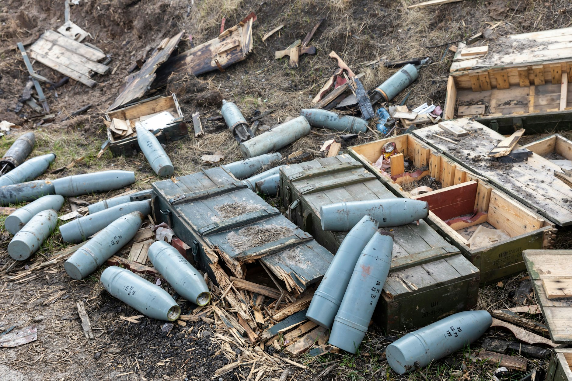 Militärausrüstung, Artilleriegranaten und leere Waffenkisten liegen nach dem Rückzug der russischen Truppen mitten auf dem Feld an der Straße bei Andrijewka.