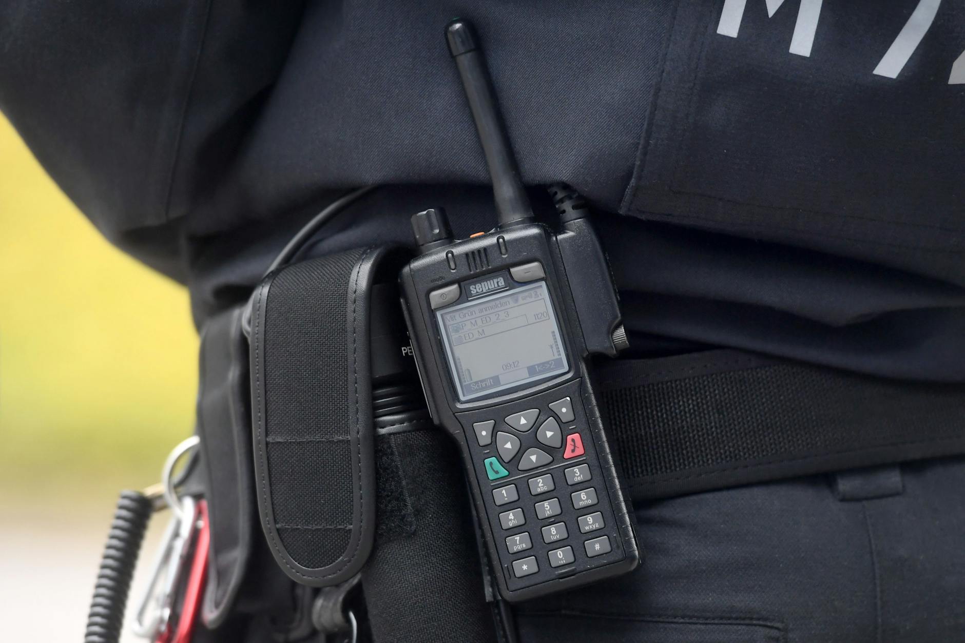 Eine Polizistin trägt ein digitales Polizei-Funkgerät am Gürtel.