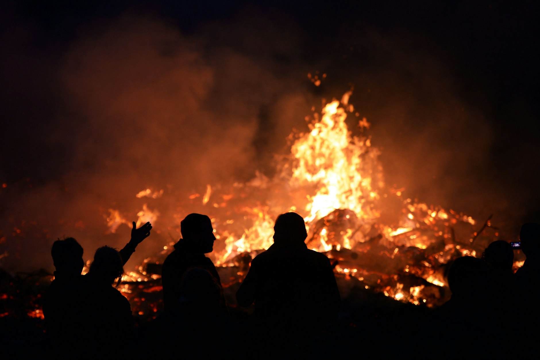 Menschen stehen an einem Osterfeuer im brandenburgischen Seeburg.