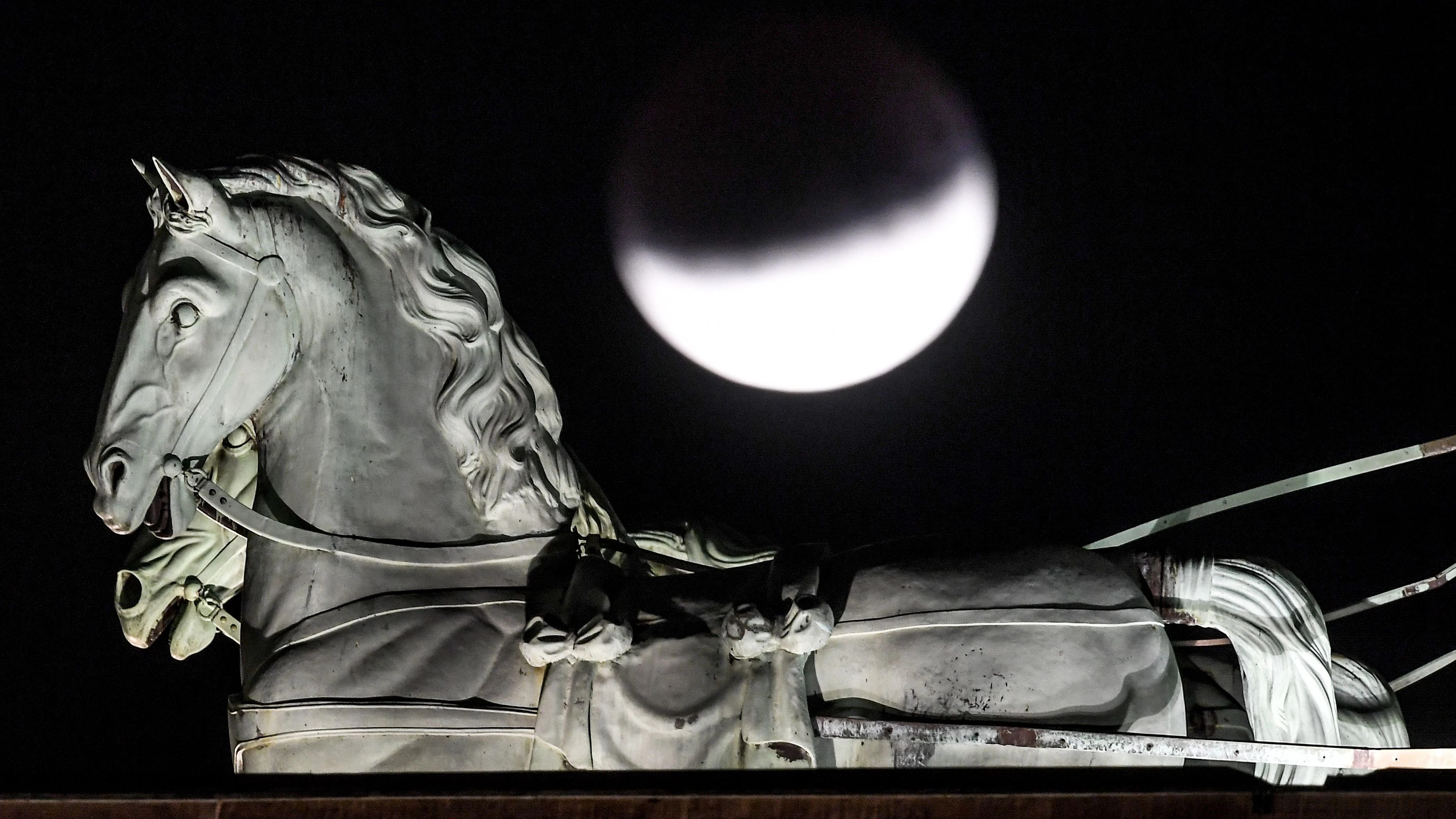 Am 16. Juli 2019: Der Mond ist während einer partiellen Mondfinsternis hinter der Quadriga des Brandenburger Tors zu sehen.