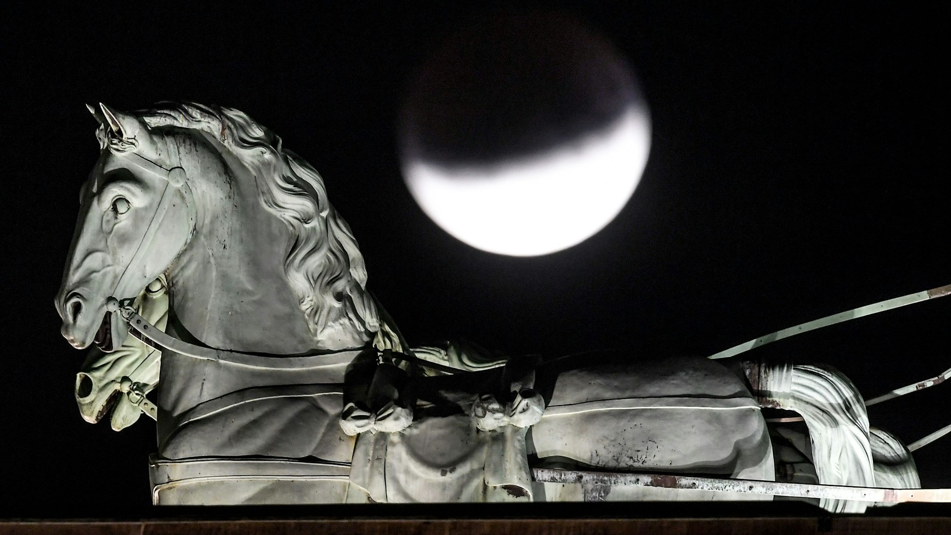 Am 16. Juli 2019: Der Mond ist während einer partiellen Mondfinsternis hinter der Quadriga des Brandenburger Tors zu sehen.