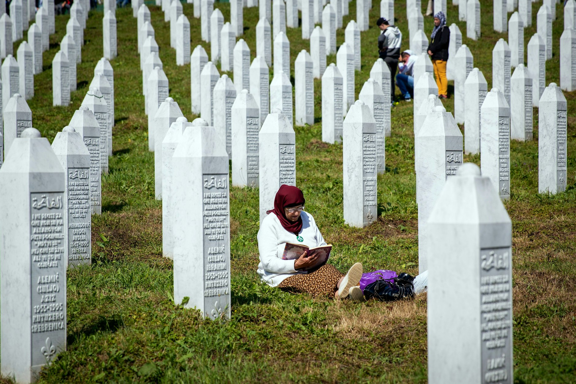 Eine Frau liest aus dem Koran auf einem Friedhof in der Nähe von Srebrenica.