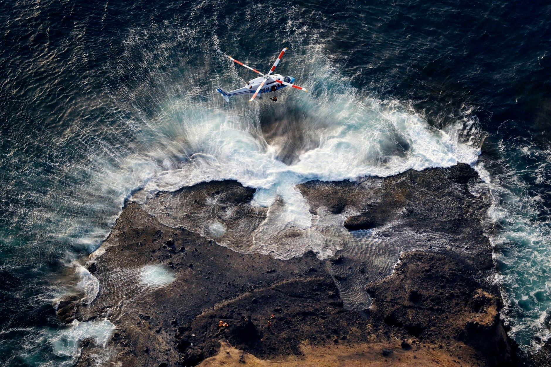 Eine Rettungskraft wird bei einer Suchaktion nach den Passagieren und Besatzungsmitgliedern des vermissten Ausflugsbootes vor der Halbinsel Shiretoko im Norden Japans angehoben.