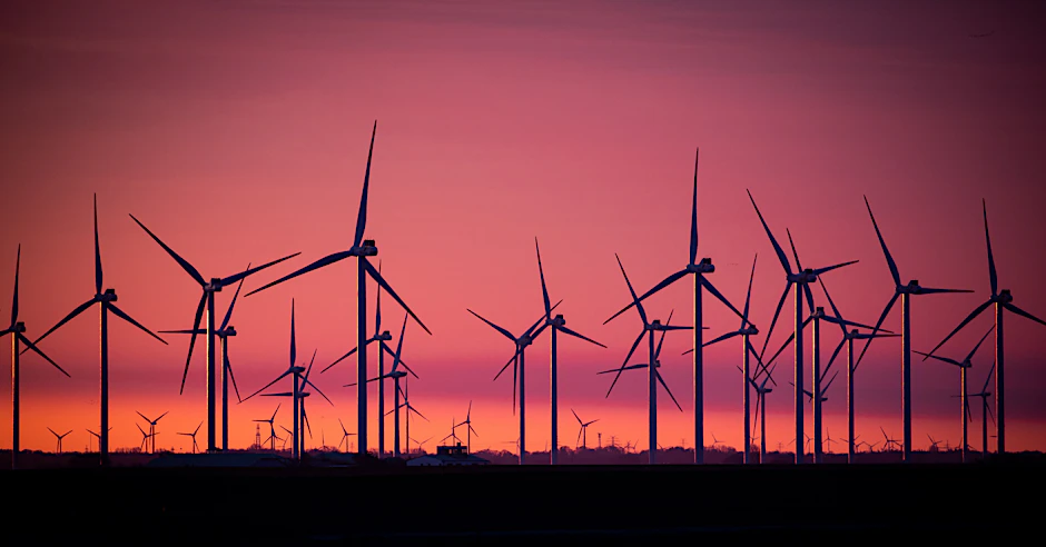 Windkraftanlagen stehen in einem Windpark im Sönke-Nissen-Koog an der Nordsee im Sonnenaufgang.