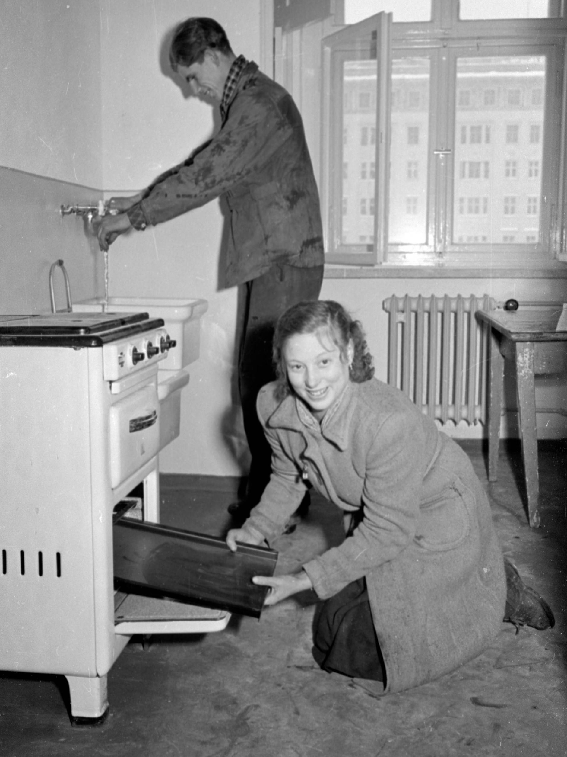 Heiß begehrt. Dieses freudestrahlende junge Paar nimmt bei seinem Einzug in den Wohnblock C an der Stalinallee 1953 die Küche in Augenschein.
