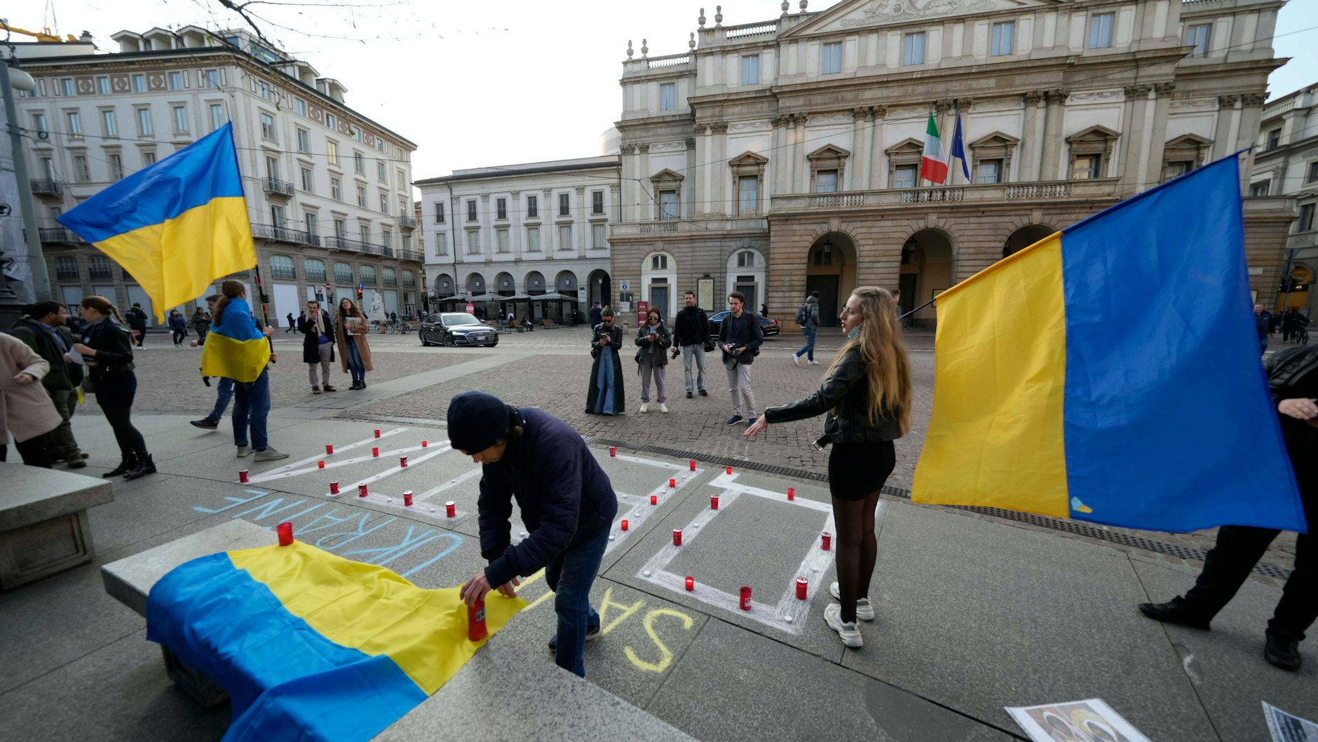 Angehörige der ukrainischen Gemeinde in Mailand halten ukrainische Flaggen vor dem Beginn eines Benefizkonzerts für die Ukraine im Teatro alla Scala am 4. April
