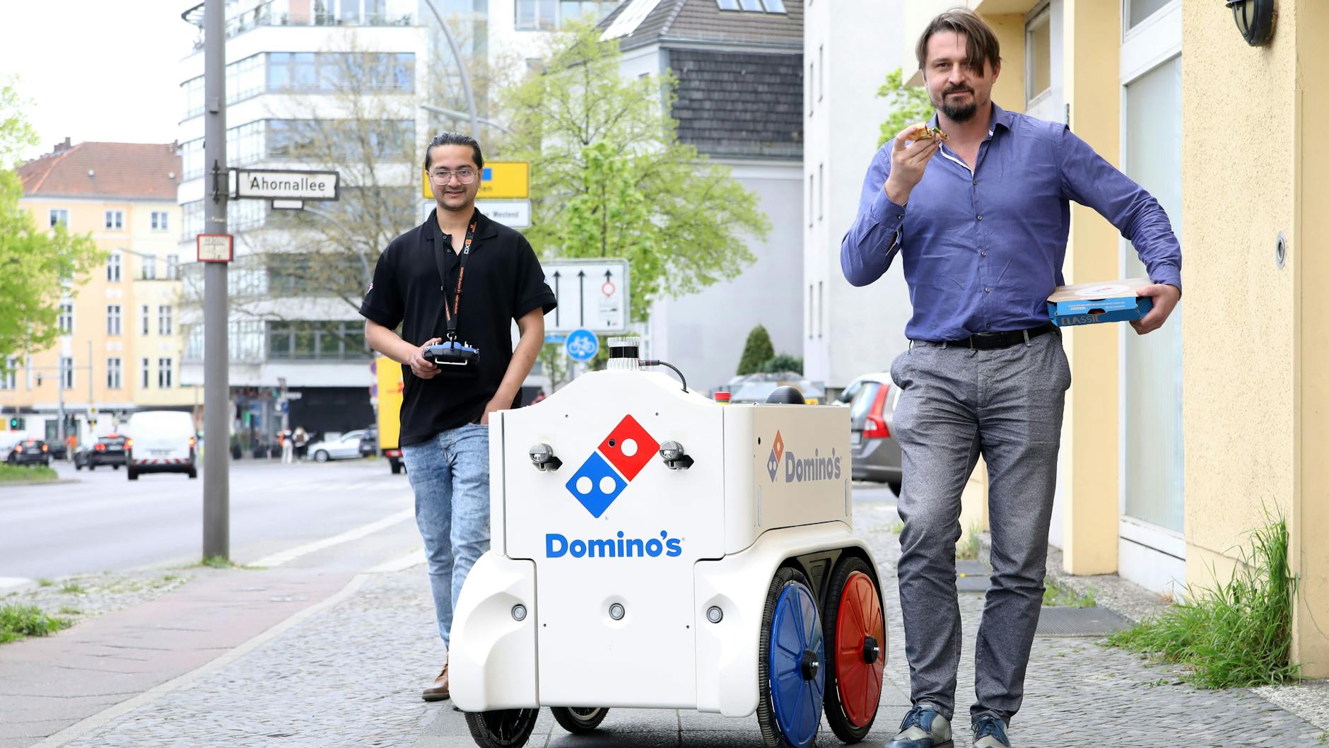 Zwei Männer und ein Roboter: Shashank Pathak überwacht die Fahrt, CEO Daniel Richart isst Pizza.