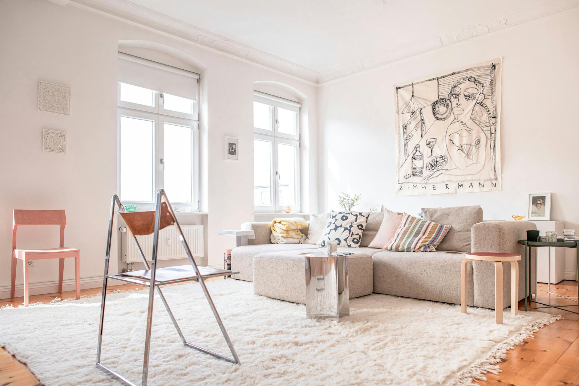 In Malaika Raiss' Wohnzimmer hängt ein Werk von Anna Zimmermann über dem HAY-Sofa.