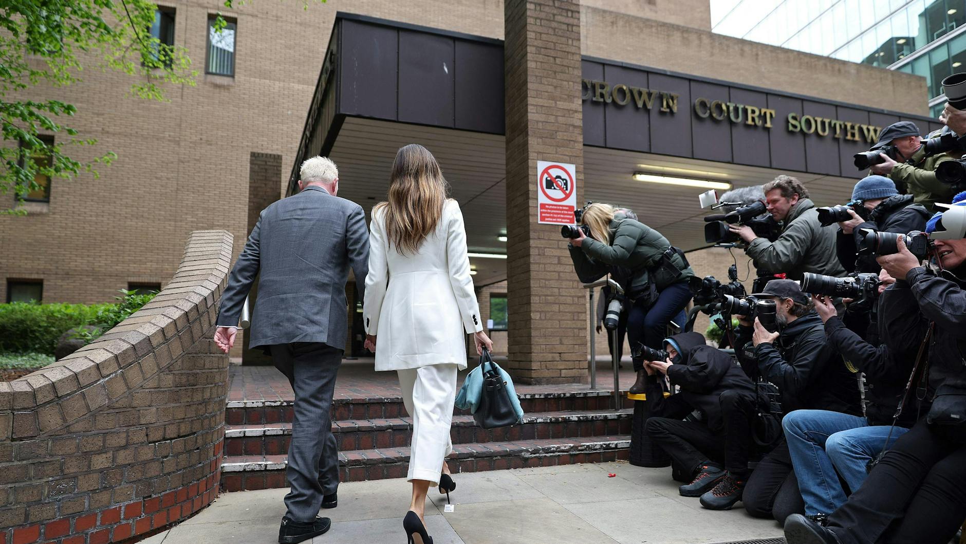 Boris Becker und Lilian de Carvalho Monteiro gehen in das Gerichtsgebäude. Medienvertreter warten.