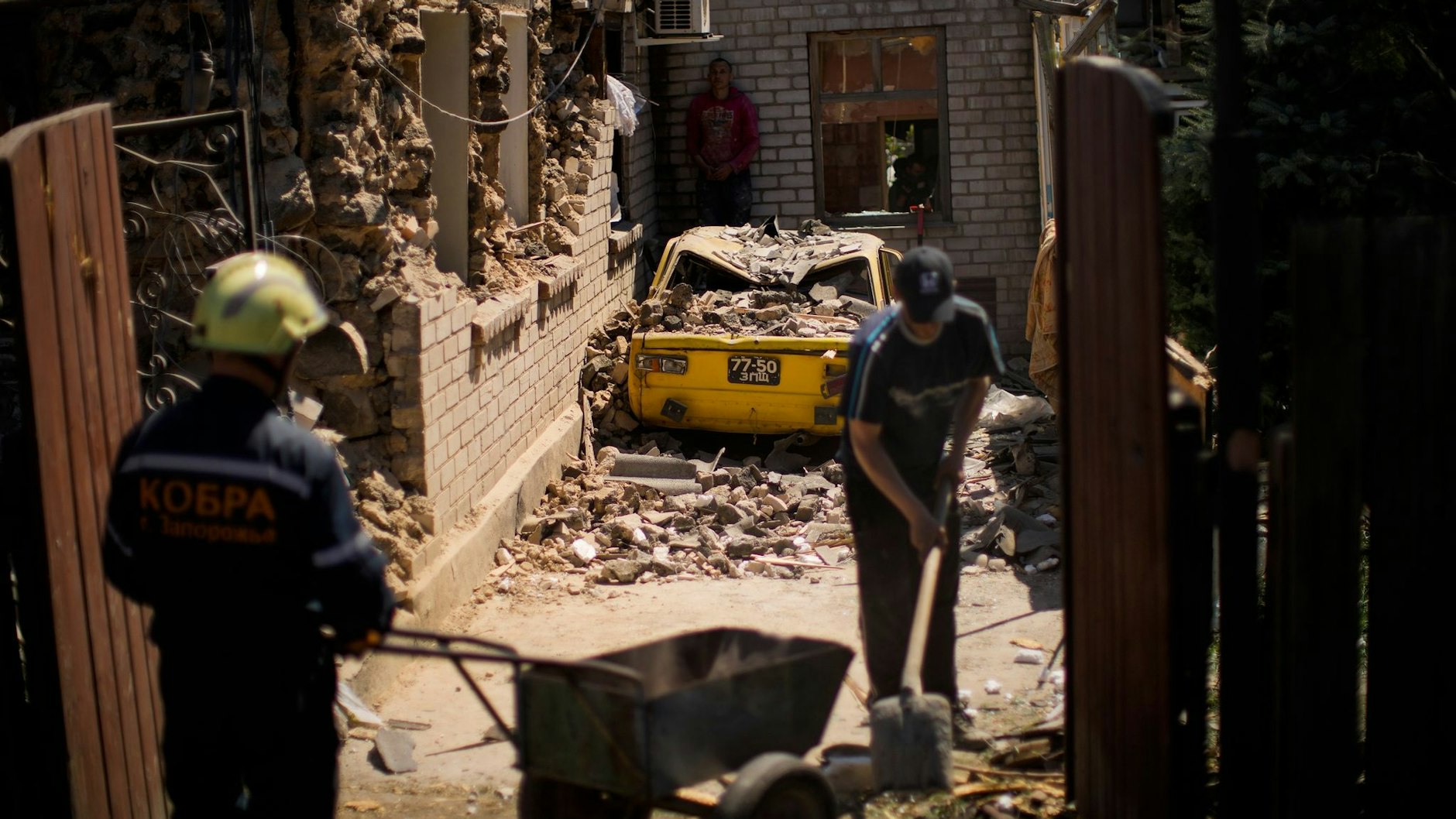 Rettungskräfte und Anwohner von Saporischschja entfernen Trümmer zerstörter Häuser. 