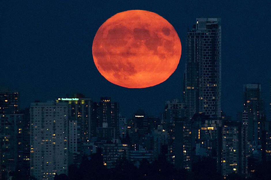 Der Vollmond geht hinter der Skyline von Downtown Vancouver auf.