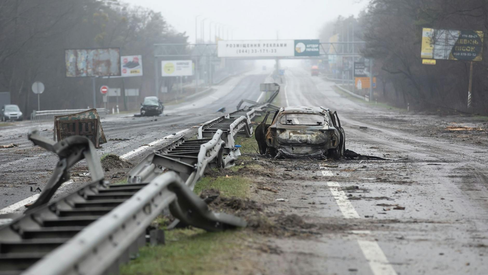 Ein zerstörtes Auto auf einer Landstraße bei Butscha.