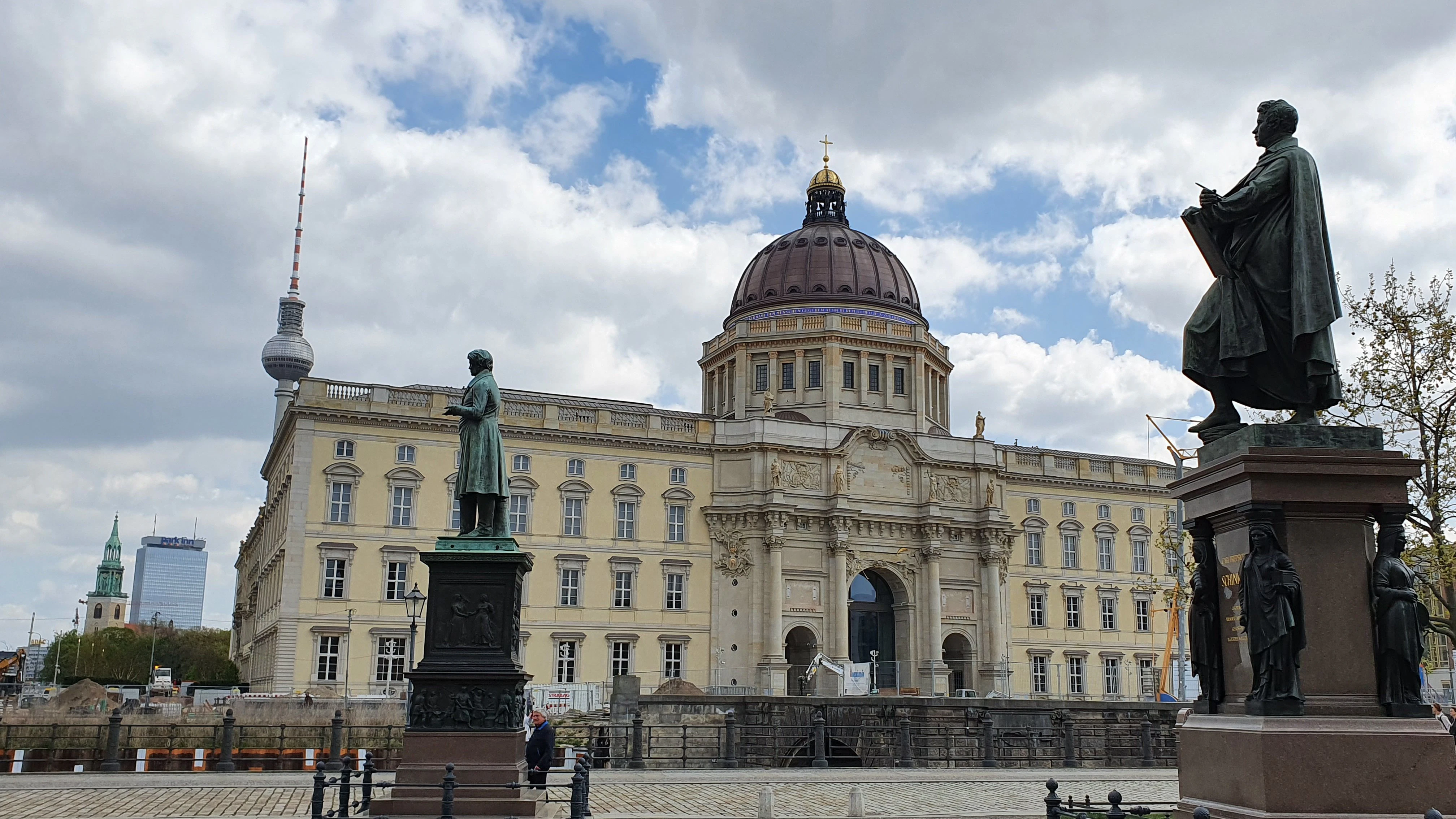 Das alt-neue Berliner Schloss als Kulisse hinter den Denkmälern am Schinkelplatz