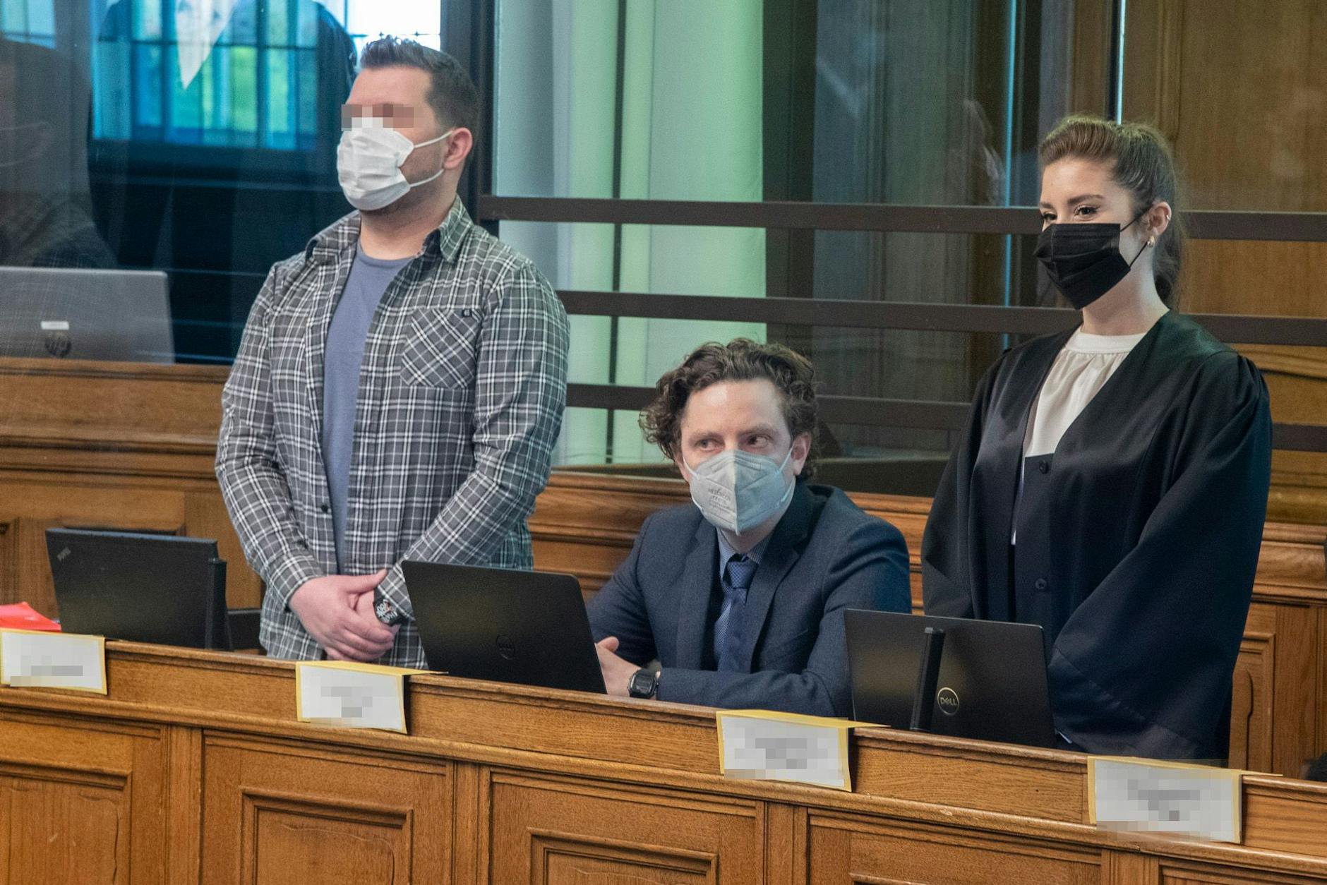 Einer der angeklagten Auto-Schmuggler (links) steht am Freitag neben seinen Anwälten in Berlin vor Gericht.