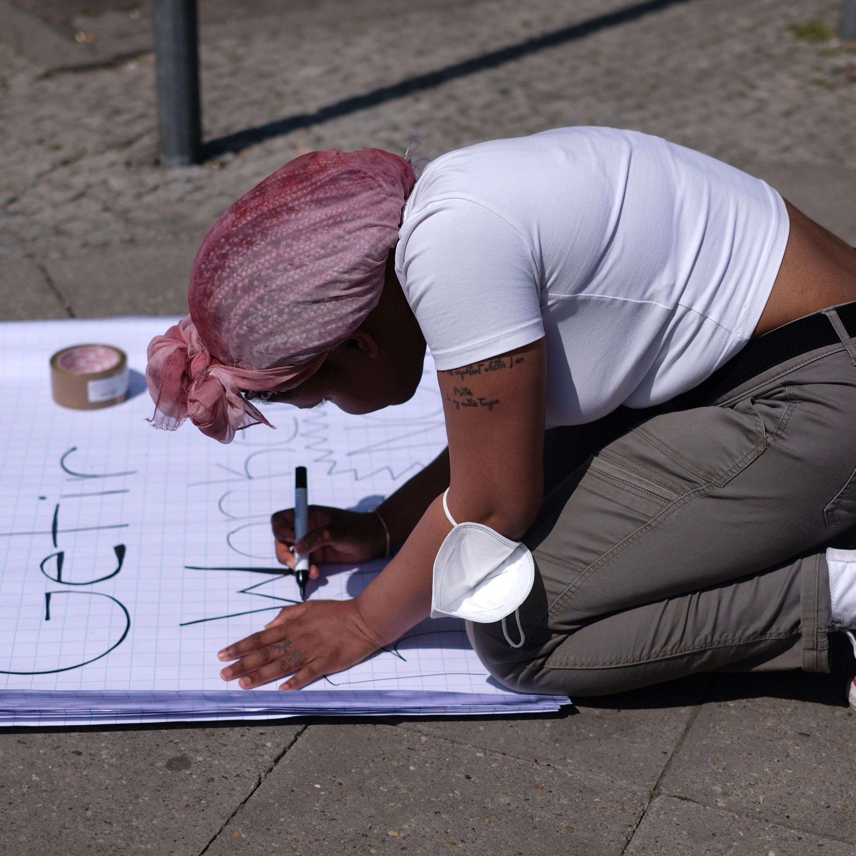 Eine Unterstützerin malt ein Plakat.