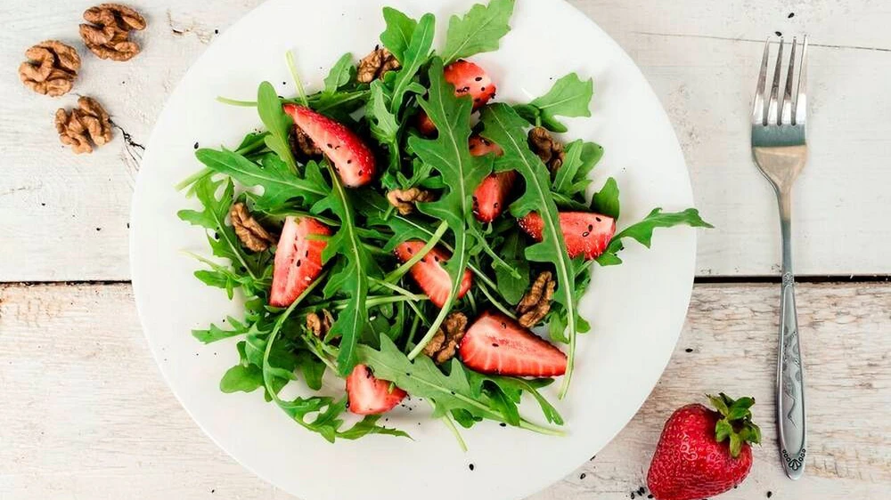 Statt mit Pinienkernen kann man den Fitness-Salat mit Erdbeeren und Rucola auch mit Walnüssen garnieren.